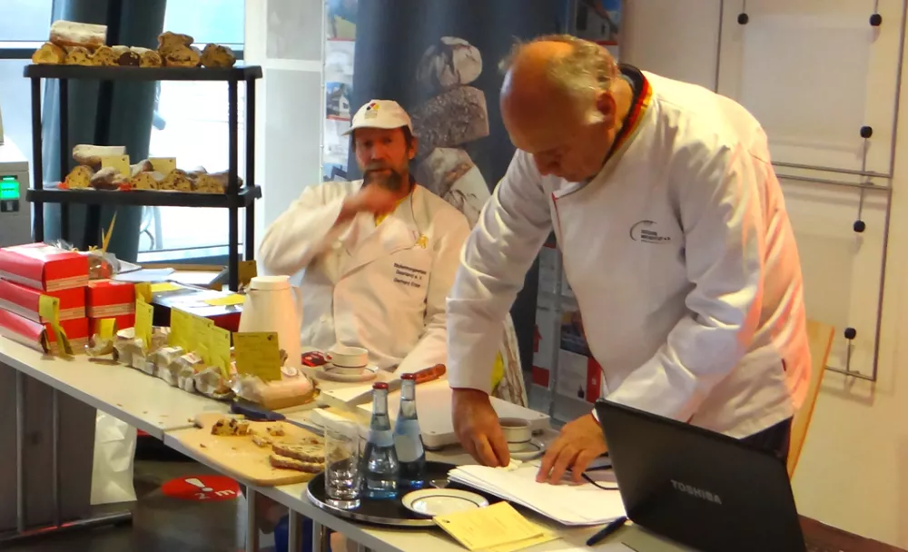 Bäckermeister Gerhard Ecker aus Erbach beobachtet im Hintergrund die Arbeit des Prüfers